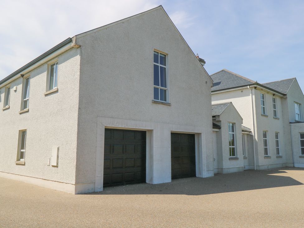 An exterior view of a house with garage doors at The East Wing Apartment in Claremorris