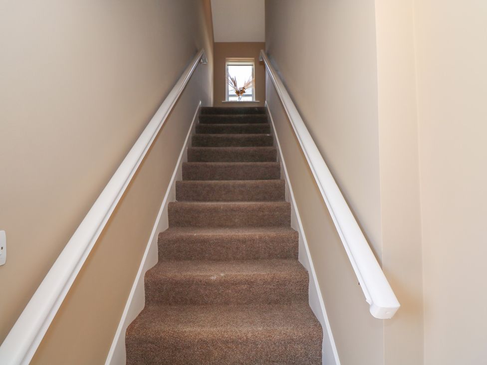 A staircase with carpet and a window at The East Wing Apartment in Claremorris