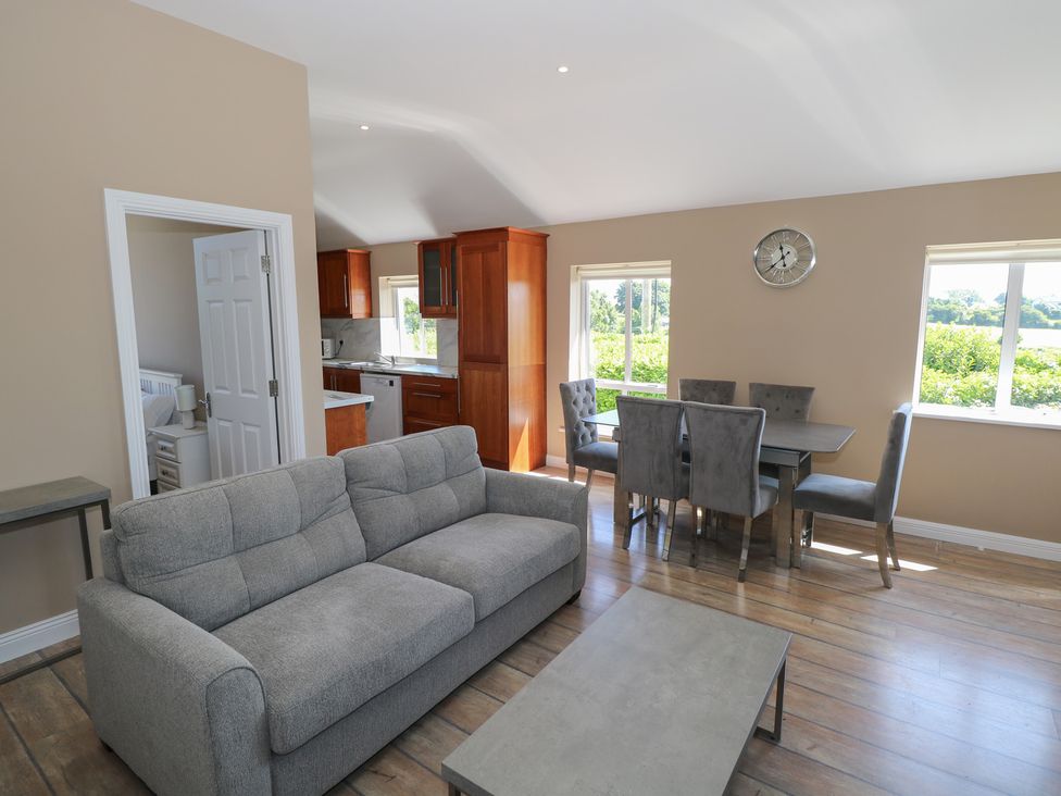 A living room with a sofa and dining area at The East Wing Apartment in Claremorris