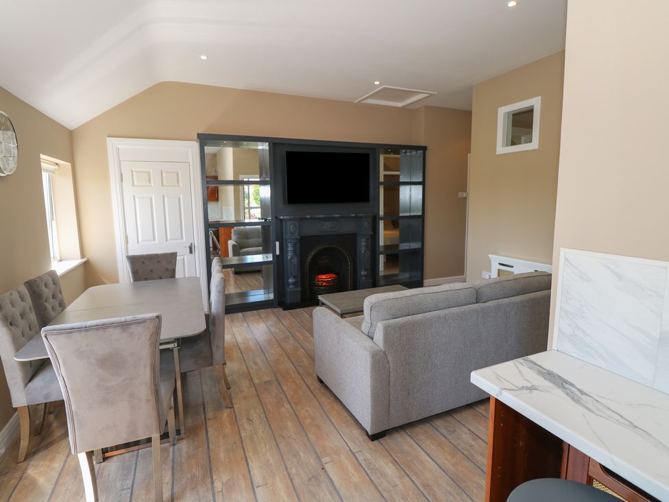 A living room with a dining table and sofa at The East Wing Apartment in Claremorris