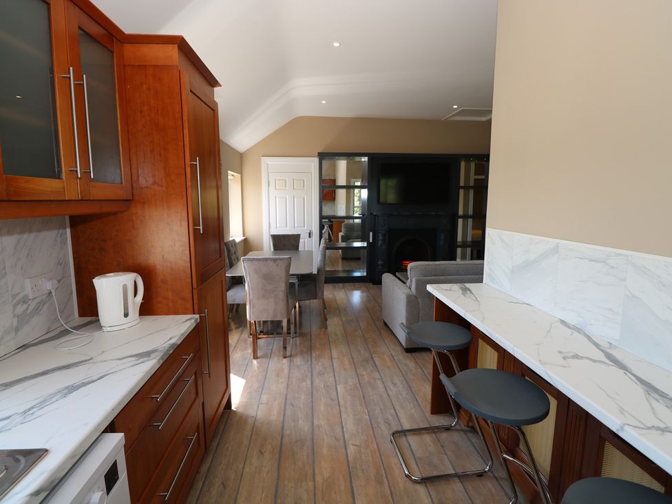 A kitchen with a dining area and a living space at The East Wing Apartment in Claremorris