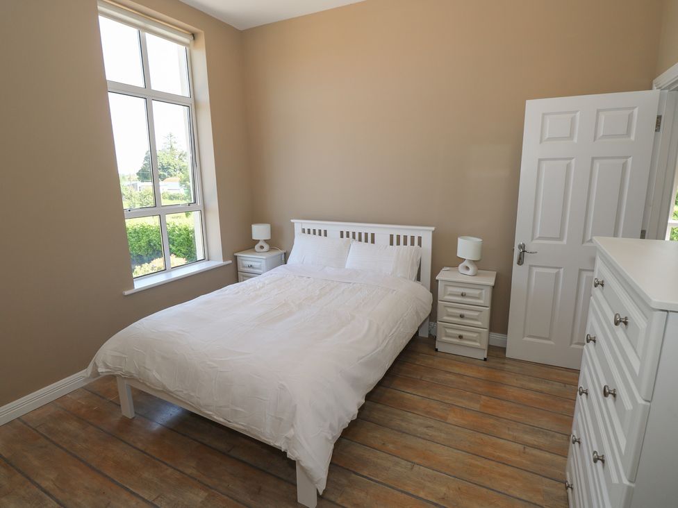 A bedroom with a bed and bedside tables at The East Wing Apartment in Claremorris