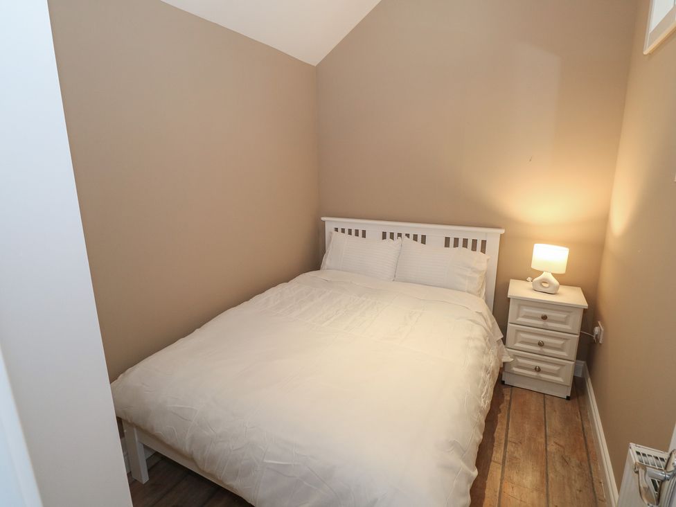 A bedroom with a bed and bedside table at The East Wing Apartment in Claremorris
