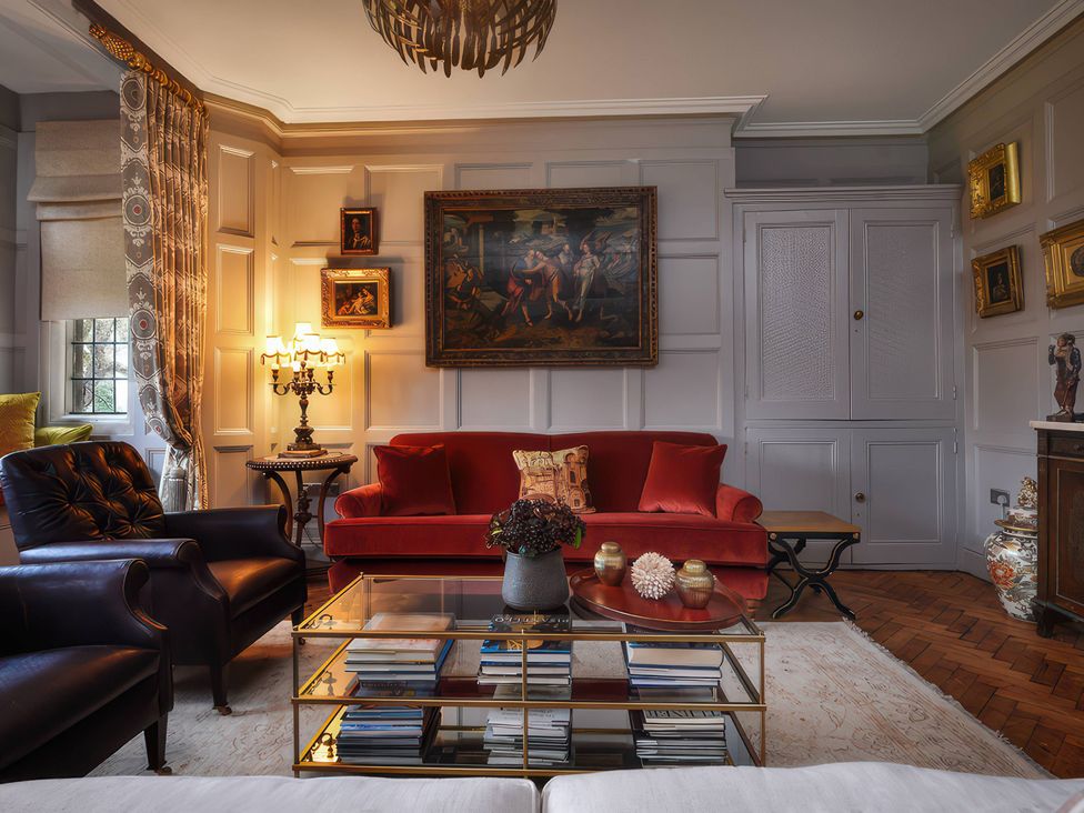 A living room with a red sofa and coffee table at Morland Manor in Peterborough