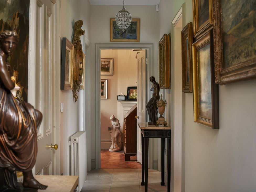 A hallway with sculptures and paintings at Morland Manor in Peterborough