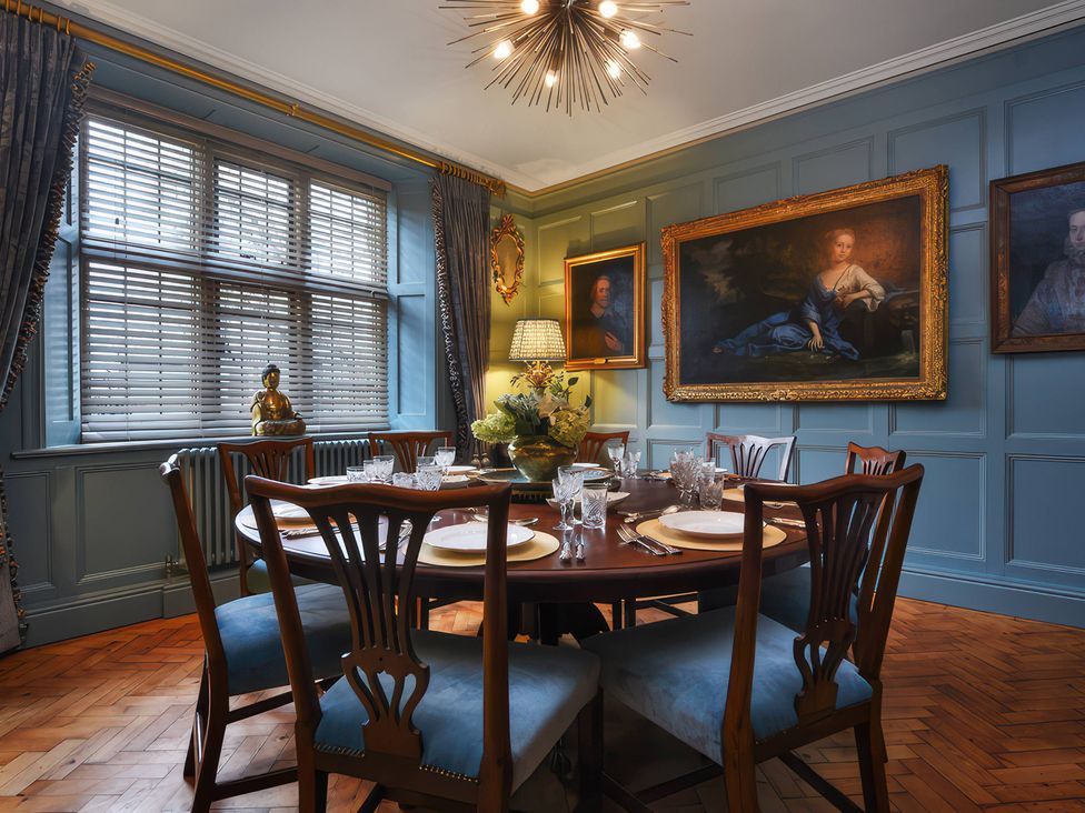 A dining room with a table and chairs at Morland Manor in Peterborough