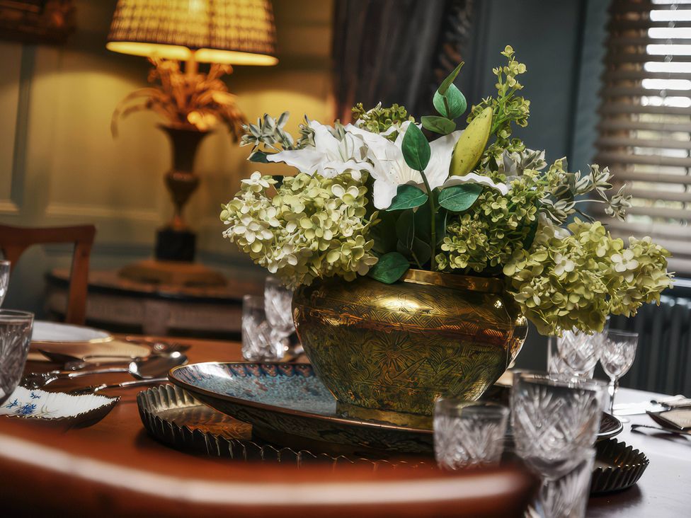 A dining room with a flower arrangement on a table at Morland Manor in Peterborough