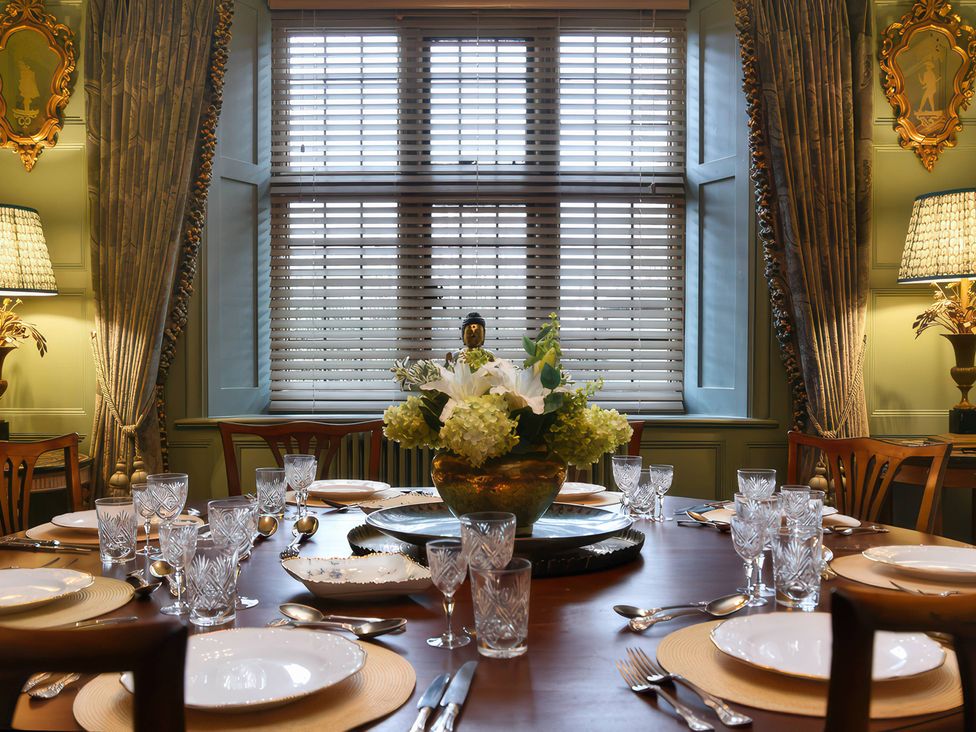 A dining room with a set table and flower arrangement at Morland Manor in Peterborough