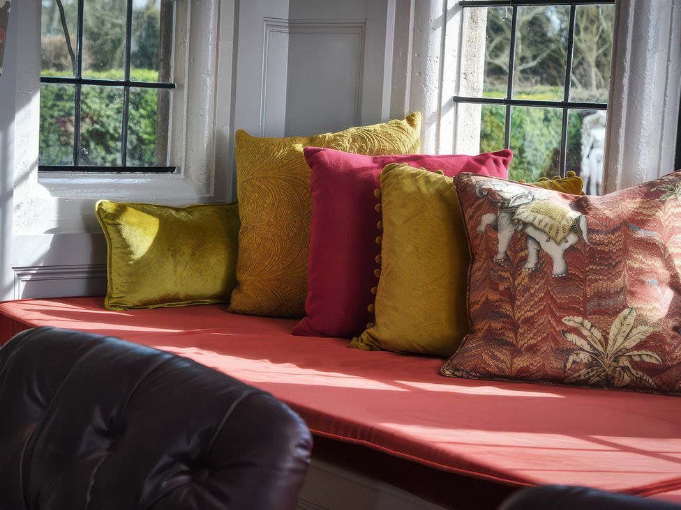 A sitting room with cushions on a seat at Morland Manor in Peterborough