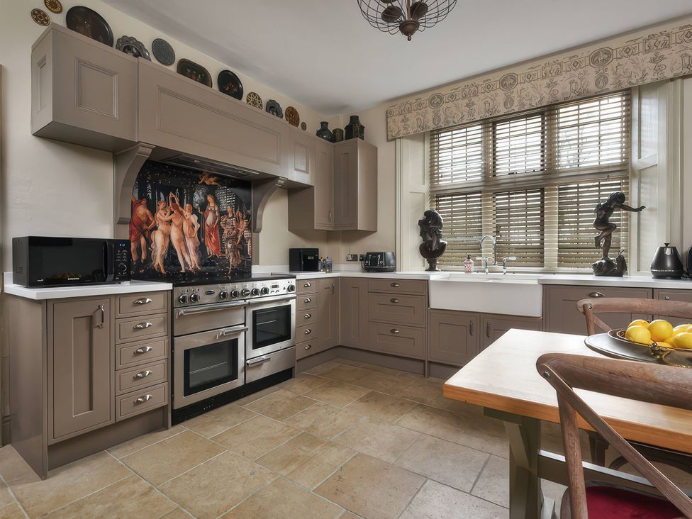A kitchen with appliances and a dining table at Morland Manor in Peterborough