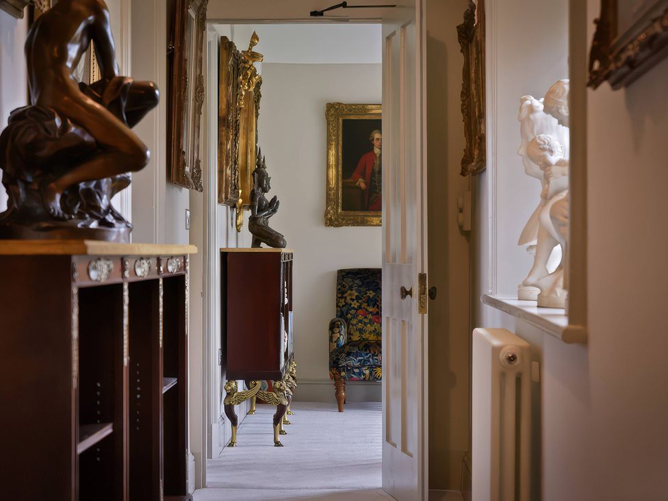 A hallway with sculptures and paintings at Morland Manor in Peterborough