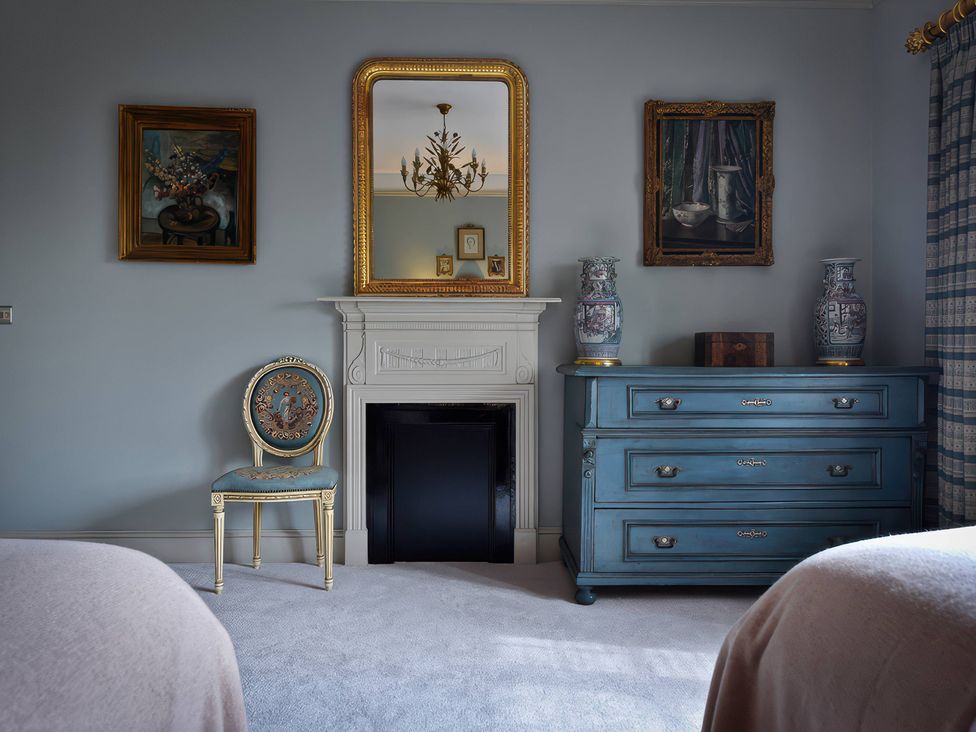 A bedroom with a fireplace and ornamental furnishings at Morland Manor Peterborough