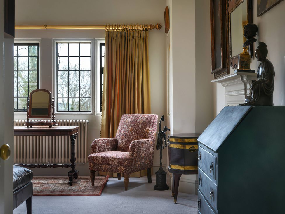 A living room with an armchair and dressing table at Morland Manor in Peterborough