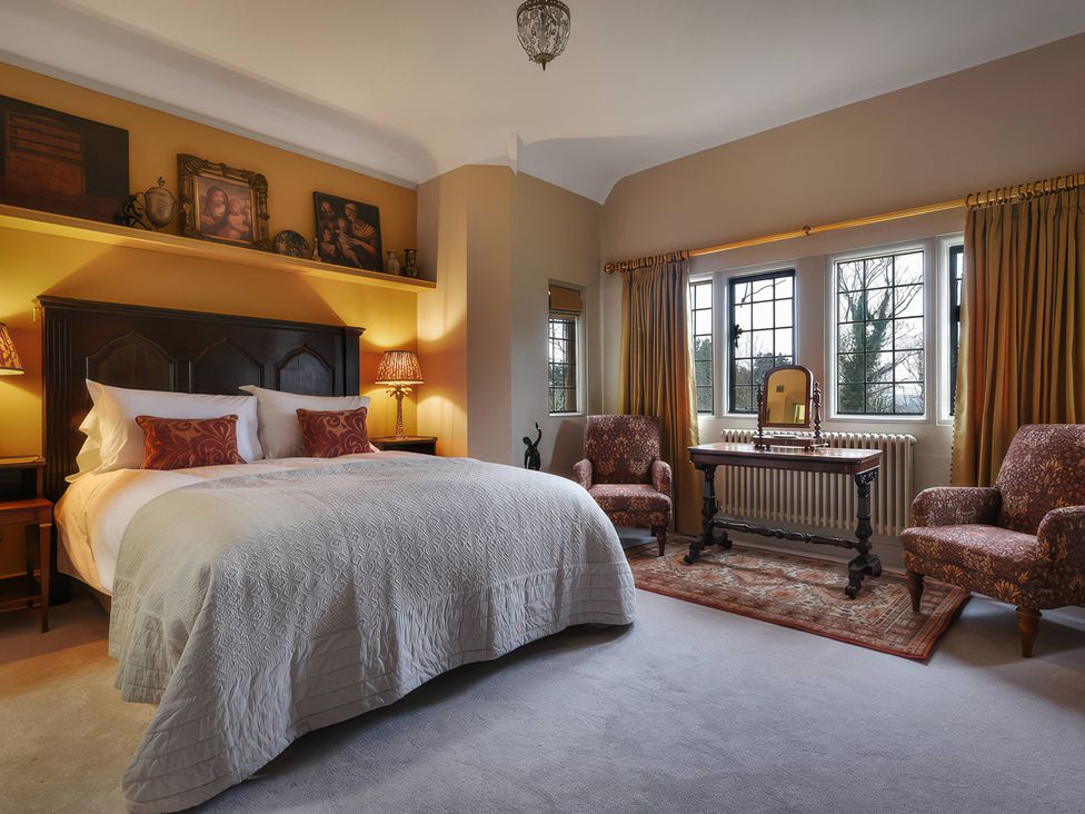 A bedroom with a bed and vanity table at Morland Manor in Peterborough