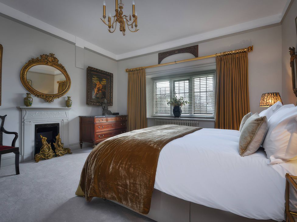 A bedroom with a bed and dresser at Morland Manor in Peterborough