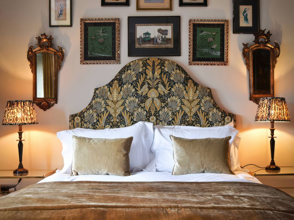 A bedroom with a bed, bedside tables, and wall art at Morland Manor Peterborough