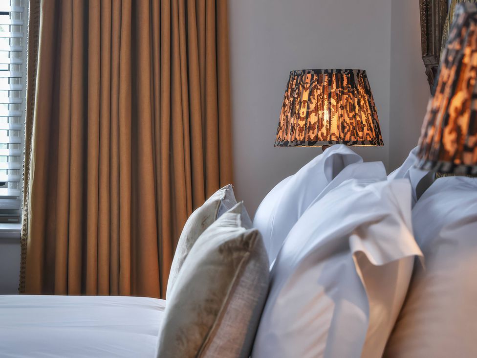A bedroom with pillows on a bed and a lamp beside the window at Morland Manor in Peterborough