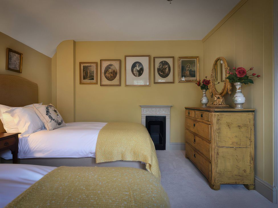 A bedroom with two beds and a dresser at Morland Manor in Peterborough