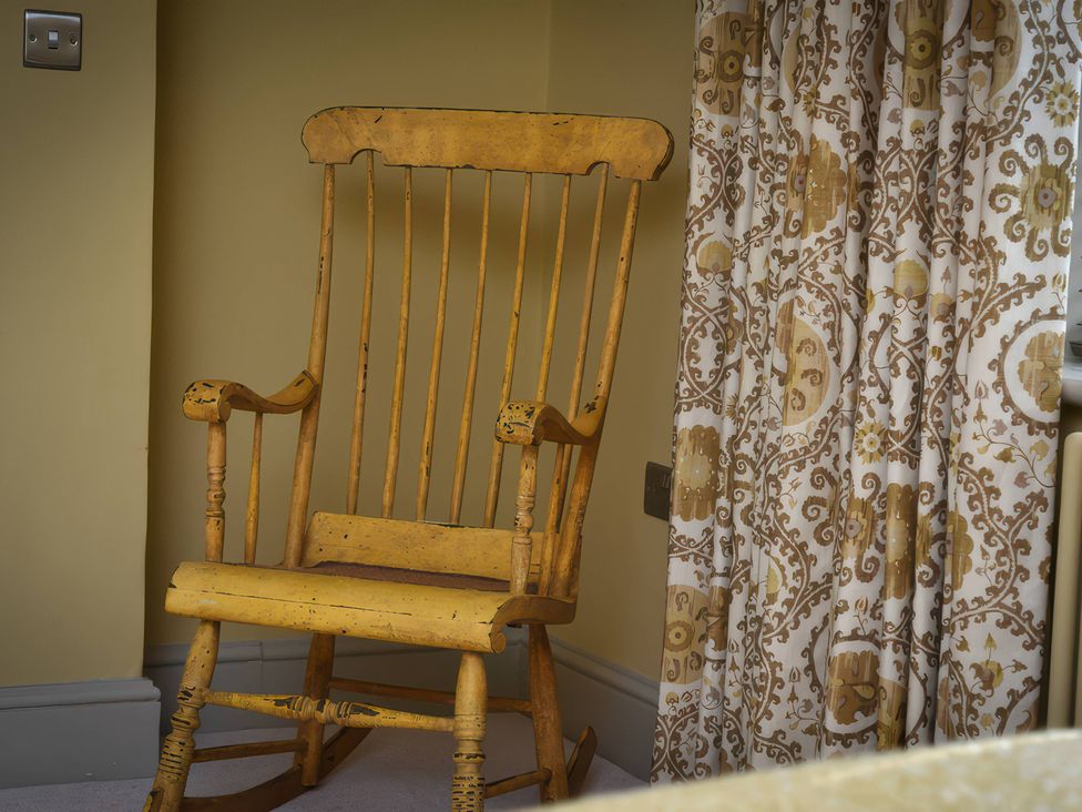 A rocking chair next to a curtain at Morland Manor in Peterborough