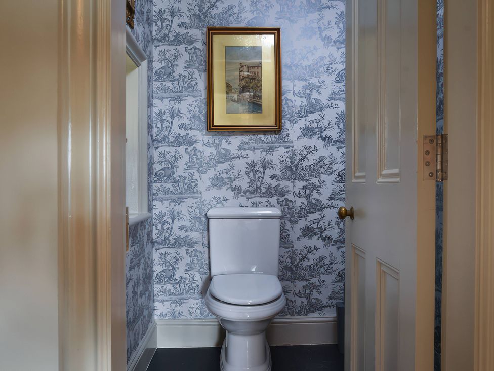 A bathroom with a toilet and framed picture at Morland Manor in Peterborough