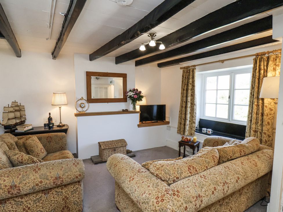 A living room with sofas and a television at Rigg Cottage in Sandsend