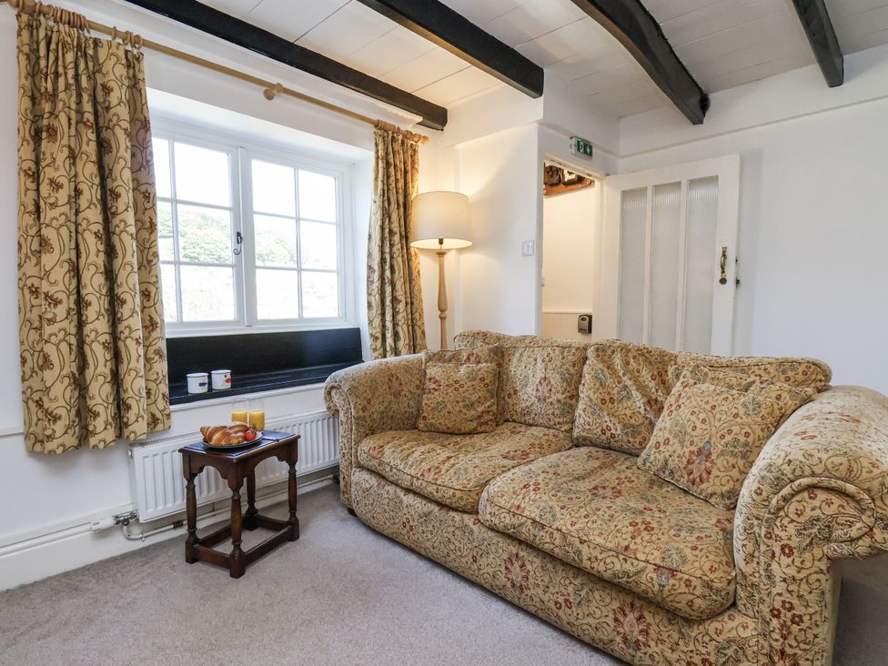 A living room with a sofa and lamp at Rigg Cottage in Sandsend