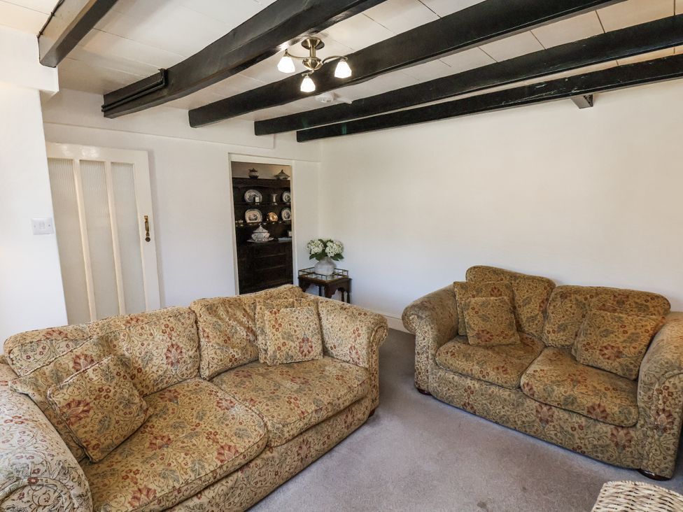 A living room with sofas and a table at Rigg Cottage Sandsend