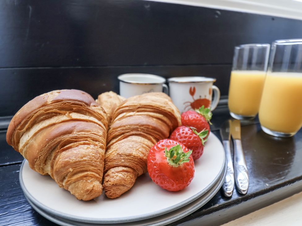 A plate with croissants and strawberries with drinks at Rigg Cottage Sandsend