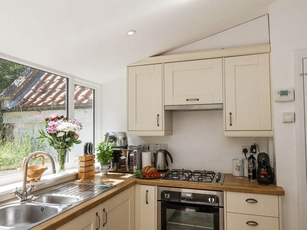 A kitchen with a stove and sink at Rigg Cottage in Sandsend