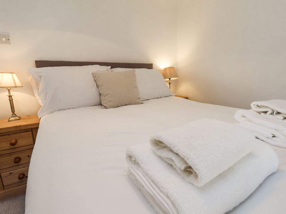 A bedroom with a bed and bedside table at Rigg Cottage in Sandsend