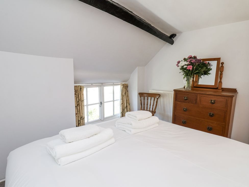 A bedroom with a bed and a dresser at Rigg Cottage in Sandsend