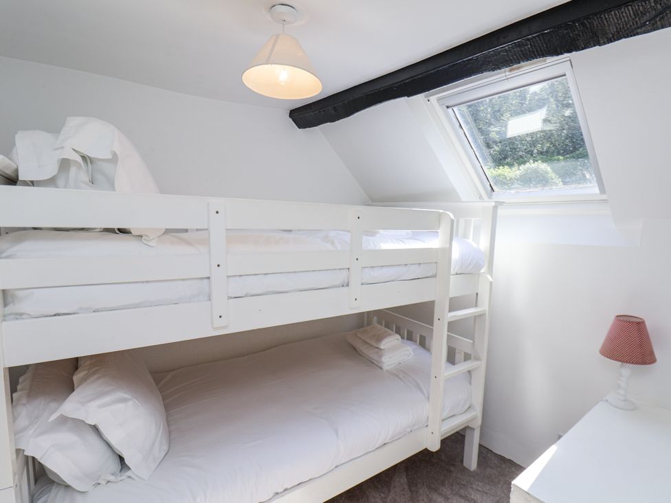 A bedroom with a bunk bed and a lamp at Rigg Cottage Sandsend