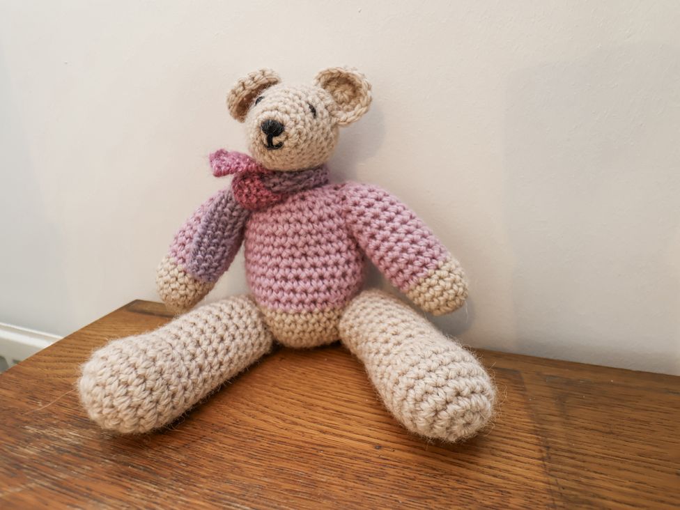 A crochet bear sitting on a wooden surface at Rigg Cottage in Sandsend