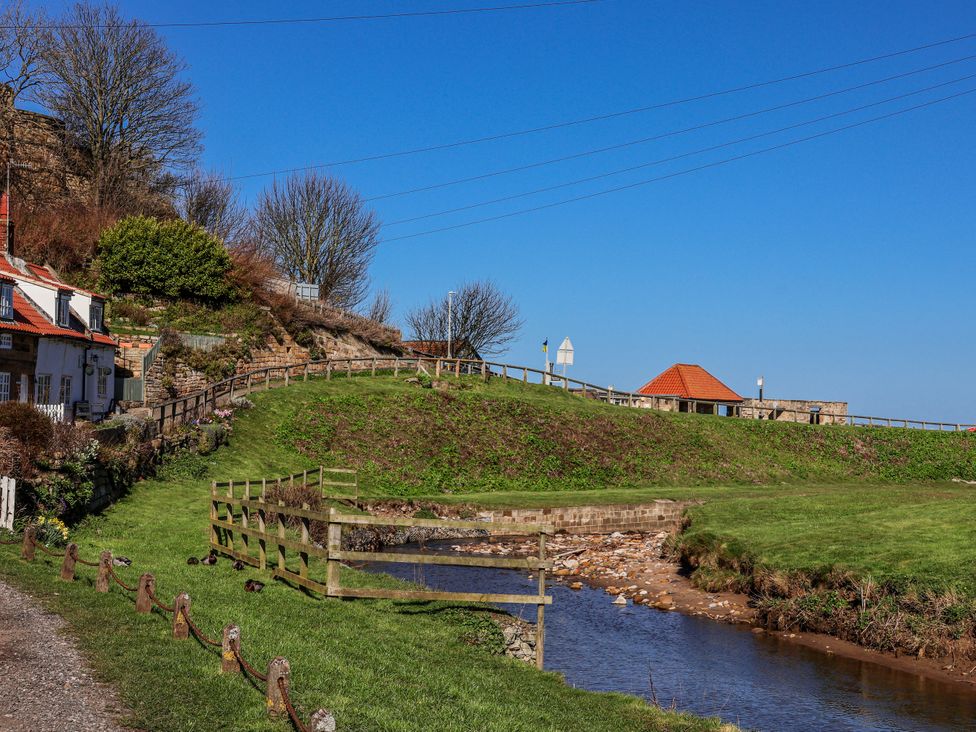 A view of houses and a stream with a fence at Rigg Cottage, Mount Pleasant Sandsend