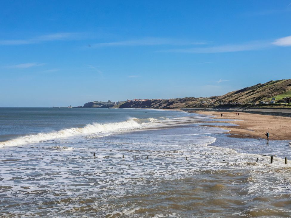 A beach scene with waves and cliffs at Rigg Cottage, Mount Pleasant Sandsend