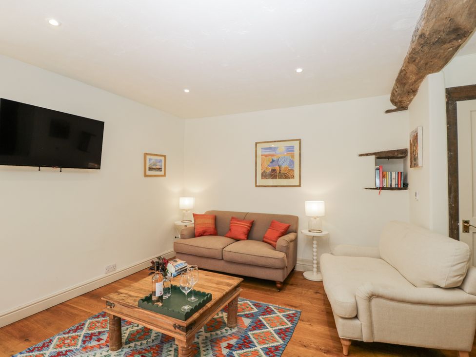 A living room with a television and sofa at Stable cottage Sopworth near Sherston
