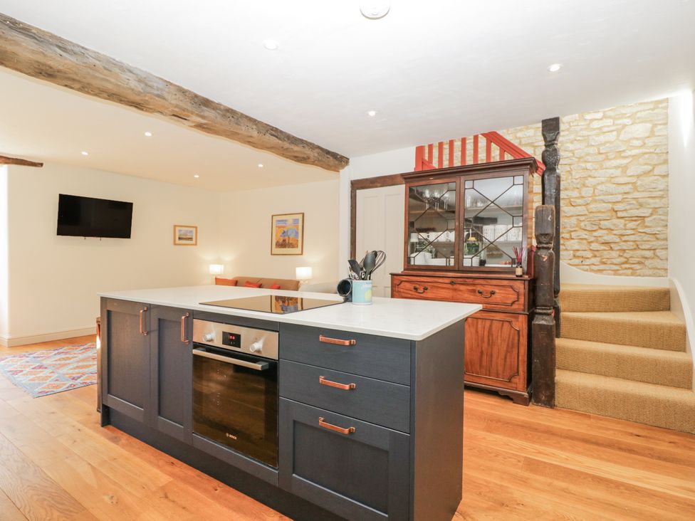 A kitchen with a central island and seating at Stable cottage Sopworth near Sherston