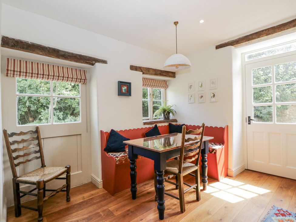 A dining room with a table and chairs at Stable cottage, Sopworth near Sherston