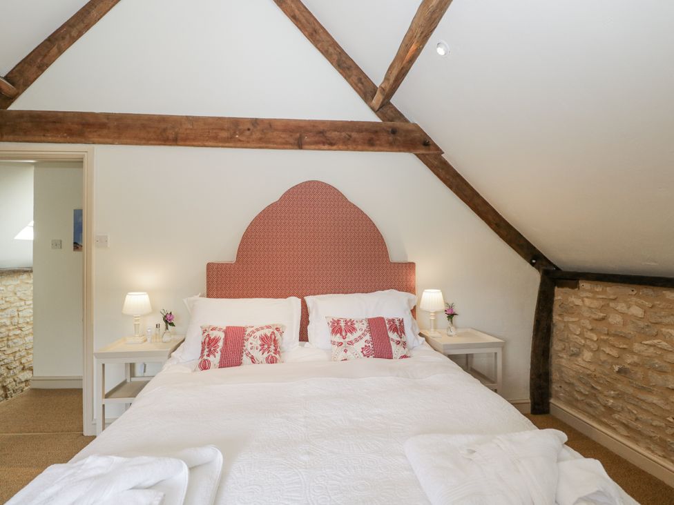 A bedroom with a bed and bedside tables at Stable Cottage in Sopworth near Sherston