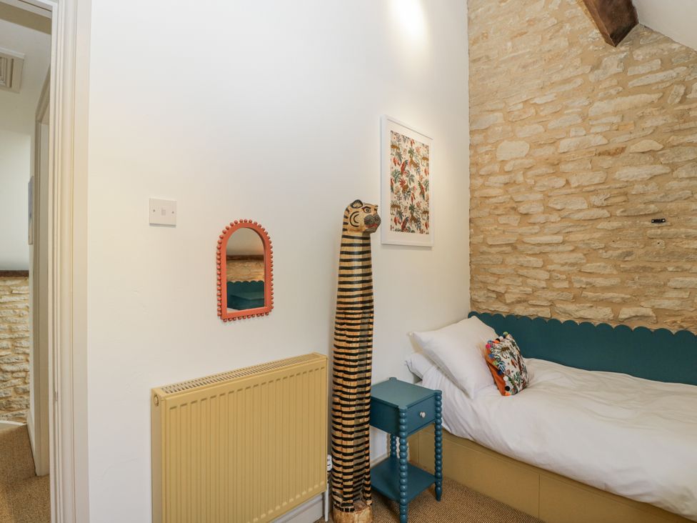 A bedroom with a bed and decorative items at Stable cottage Sopworth near Sherston