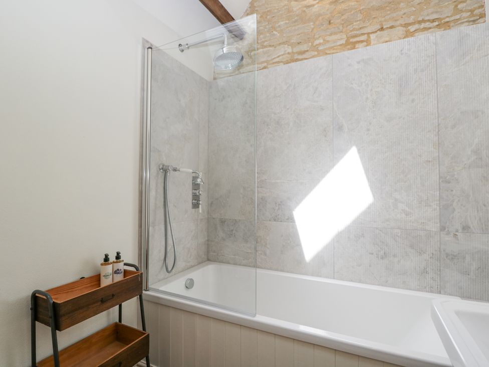 A bathroom with a bathtub and shower at Stable cottage Sopworth near Sherston