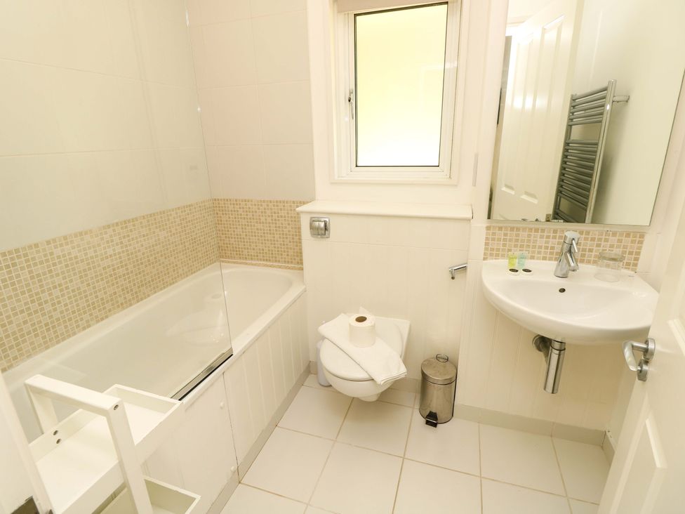 A bathroom with a bathtub shower toilet and sink at Whitfield P1 in Yarmouth