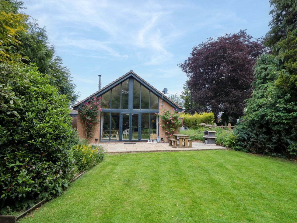 A house with large windows and a patio in the garden at Lawnswood