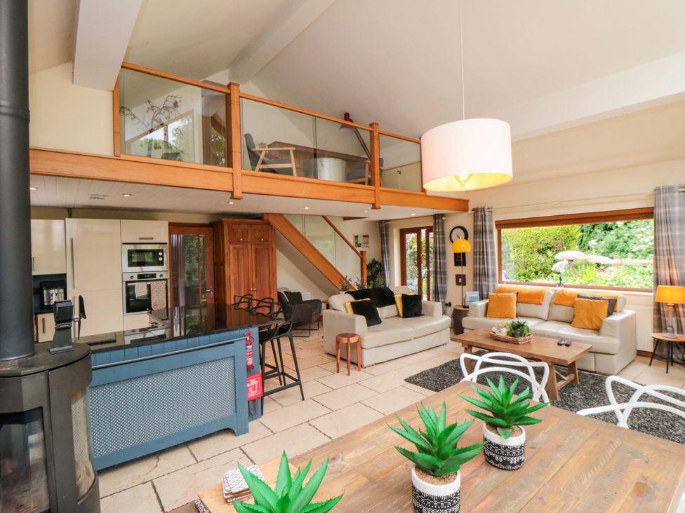 A living room with a staircase and kitchen appliances at Lawnswood