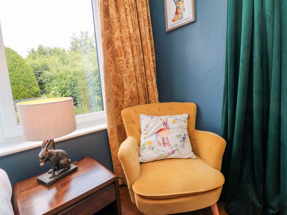 A sitting room with a chair and lamp at Lawnswood
