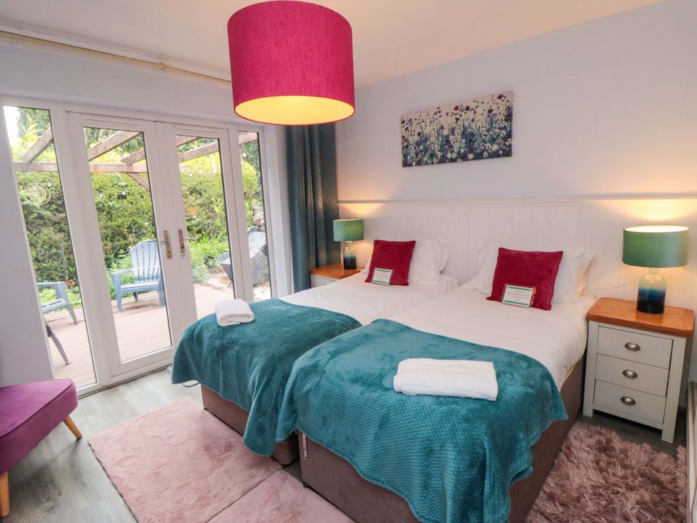 A bedroom with two beds and sliding doors at Lawnswood