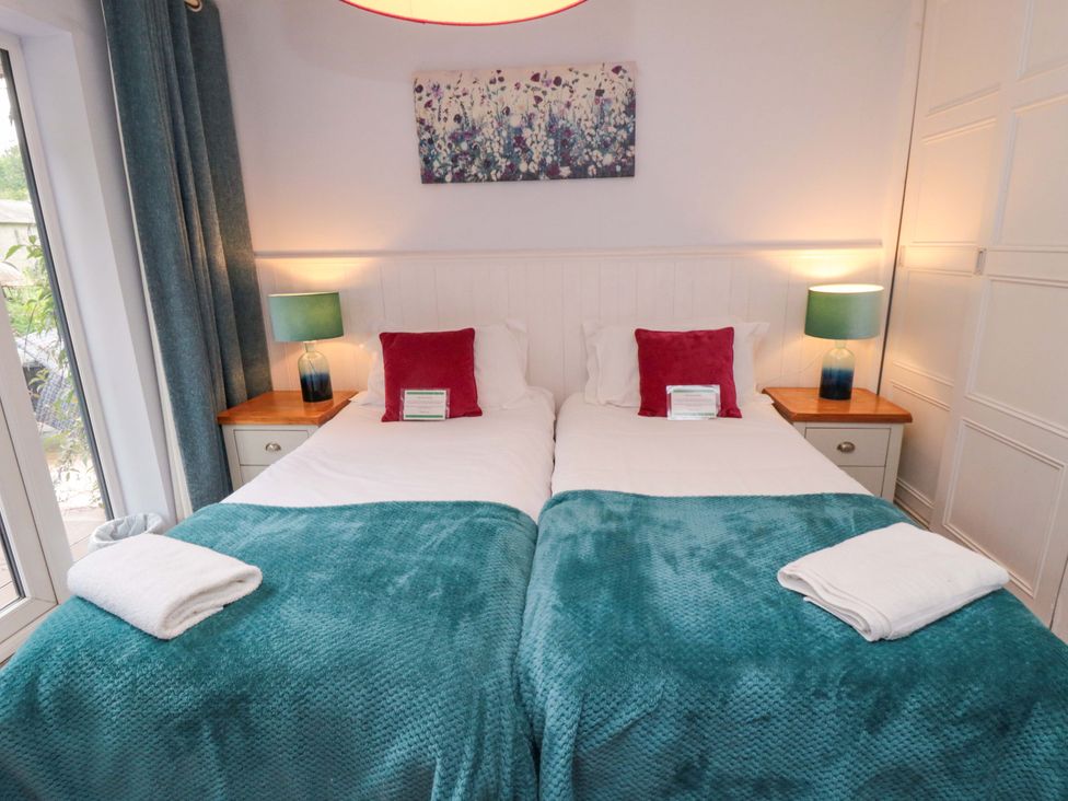 A bedroom with twin beds and a bedside table at Lawnswood