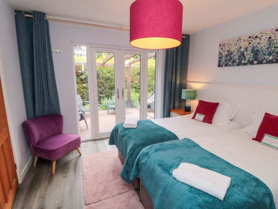 A bedroom with twin beds and a chair at Lawnswood
