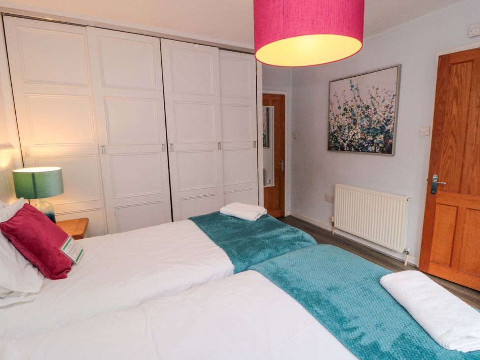 A bedroom with two beds and a wardrobe at Lawnswood