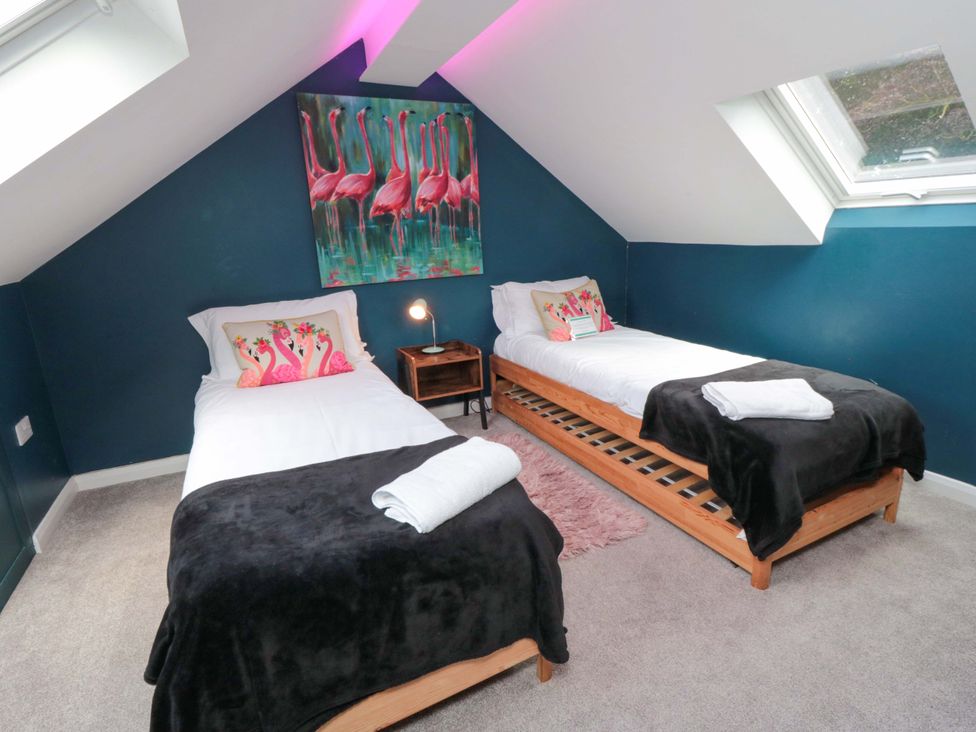 A bedroom with two beds and wall art at Lawnswood